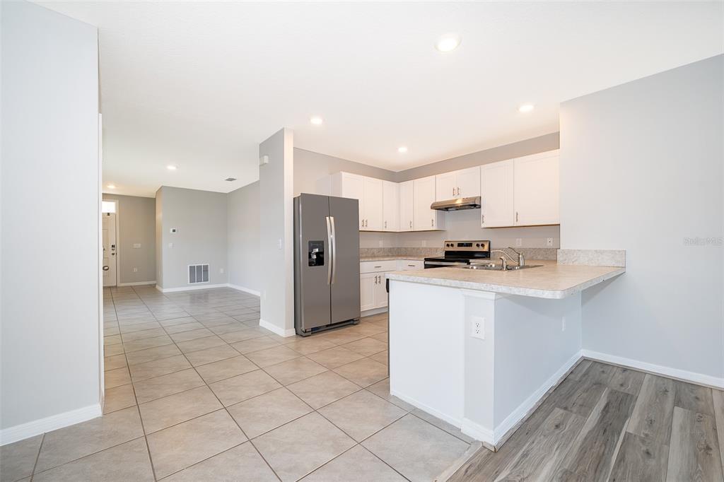 1500 Quinta Road Kissimmee, FL 34744 - Photo 6 of 34 a kitchen with stainless steel appliances granite countertop a refrigerator and a stove top oven