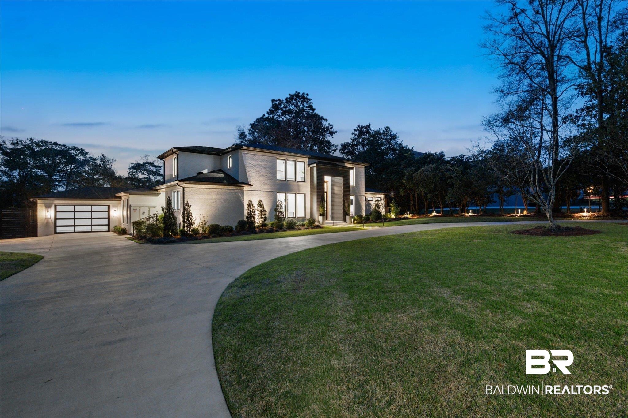 69 Jordan Lane Mobile, AL 36608 - Photo 44 of 57 View of front of property featuring curved driveway, stucco siding, a garage, and a yard