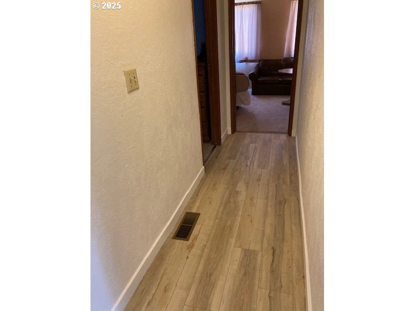 3107 Southwest Ladow Avenue Pendleton, OR 97801 - Photo 12 of 34 a view of a hallway with wooden floor and a bathroom