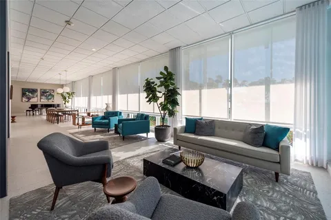a living room with furniture potted plant and a large window