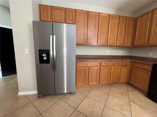 a view of a kitchen with refrigerator and cabinet