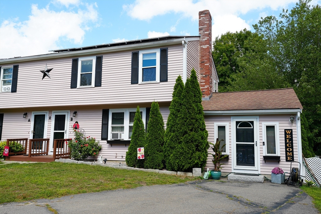a front view of a house with a garden and plants