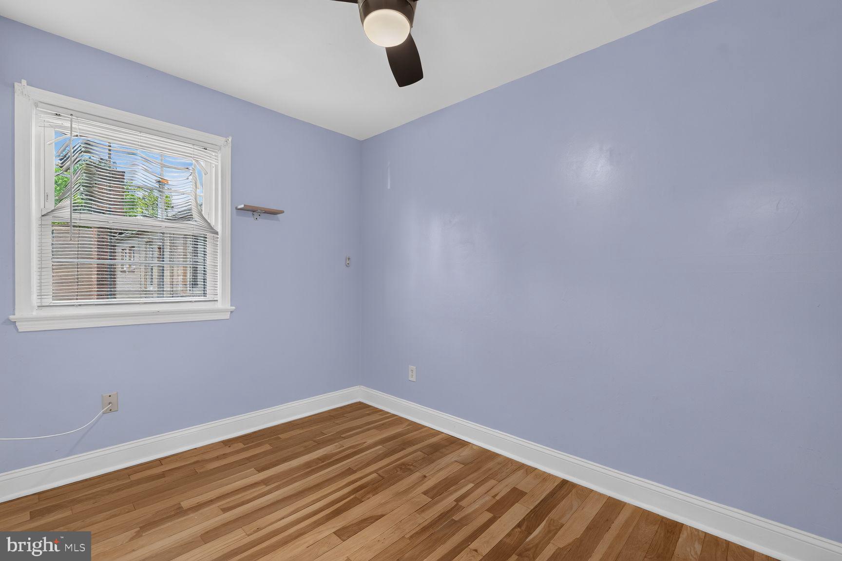 2437 Iverson Street Temple Hills, MD 20748 - Photo 12 of 15 a view of an empty room with wooden floor and a window