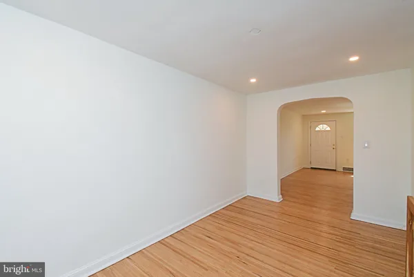 a view of an empty room with wooden floor and closet