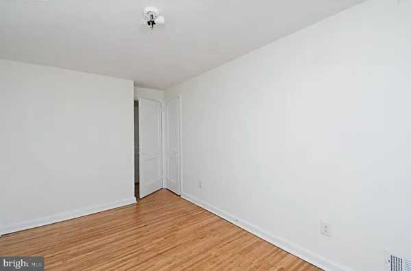 a view of a room with wooden floor and white walls