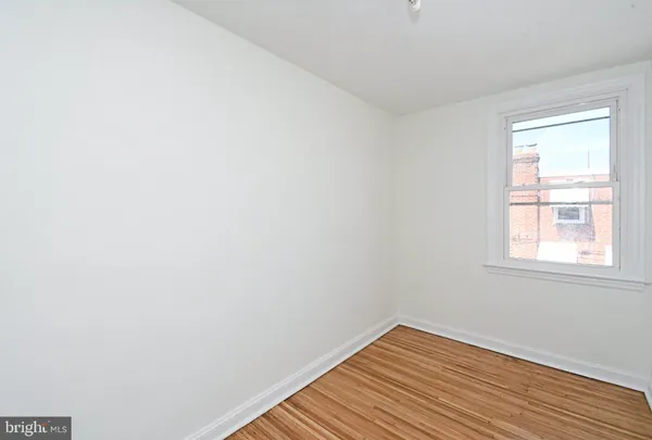 a view of a room with wooden floor and fan