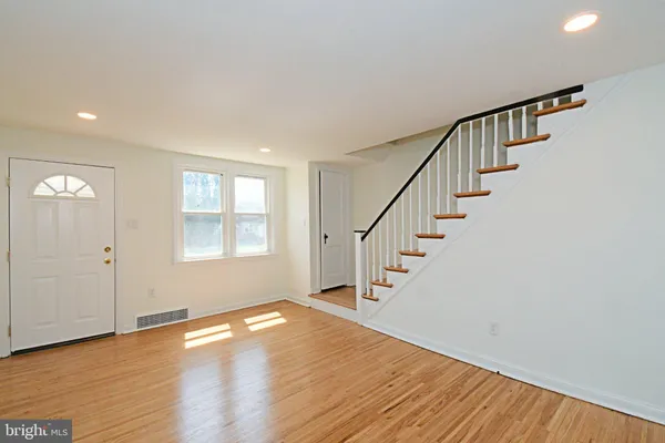 a view of entryway with wooden floor and stairs