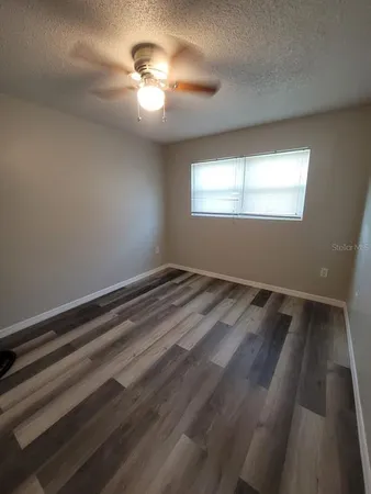 a view of a room with a ceiling fan and window