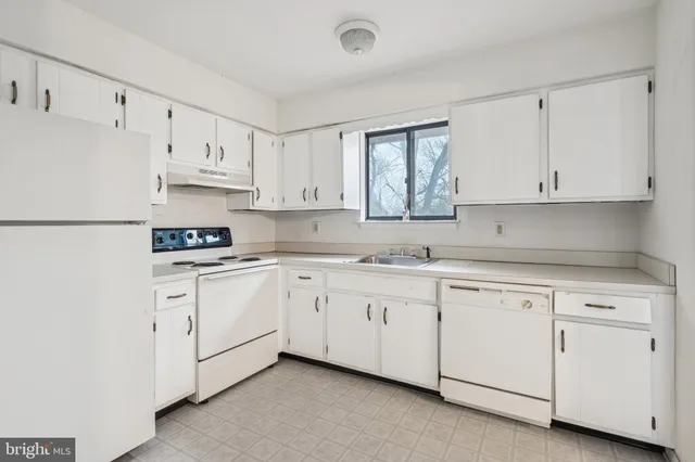 a kitchen with cabinets appliances a sink and a window