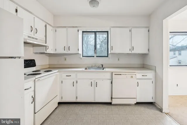 a kitchen with cabinets appliances a sink and a window