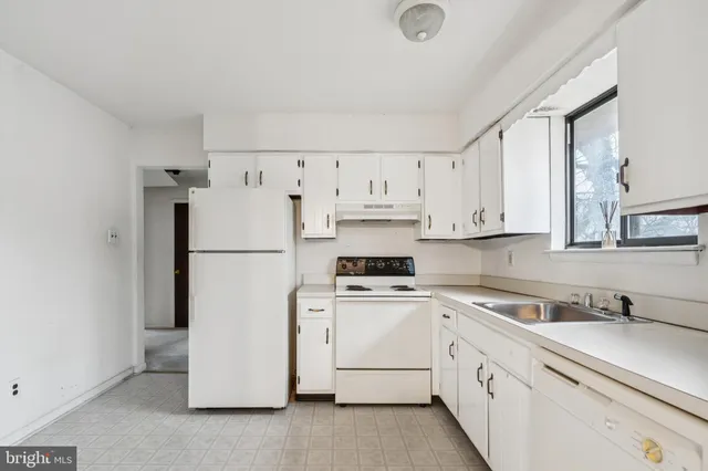 a kitchen with white cabinets and white appliances
