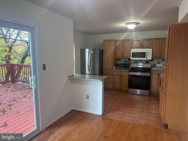 a kitchen with granite countertop a stove and a refrigerator