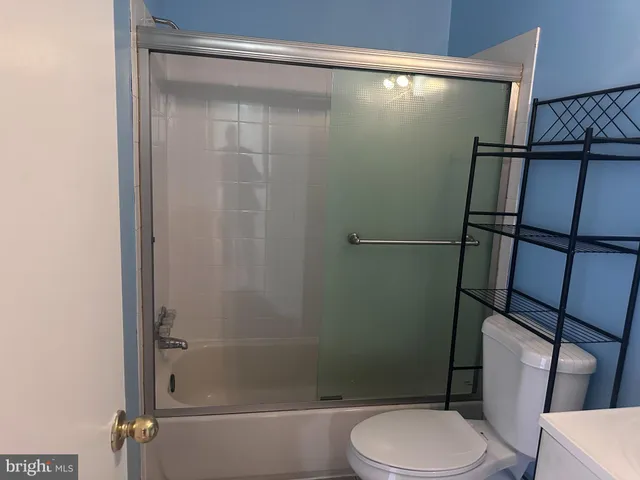 a white toilet sitting next to a shower