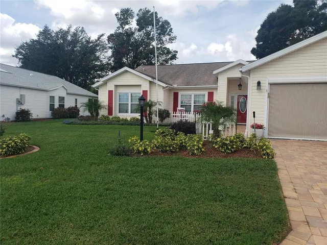 a front view of a house with a yard and trees