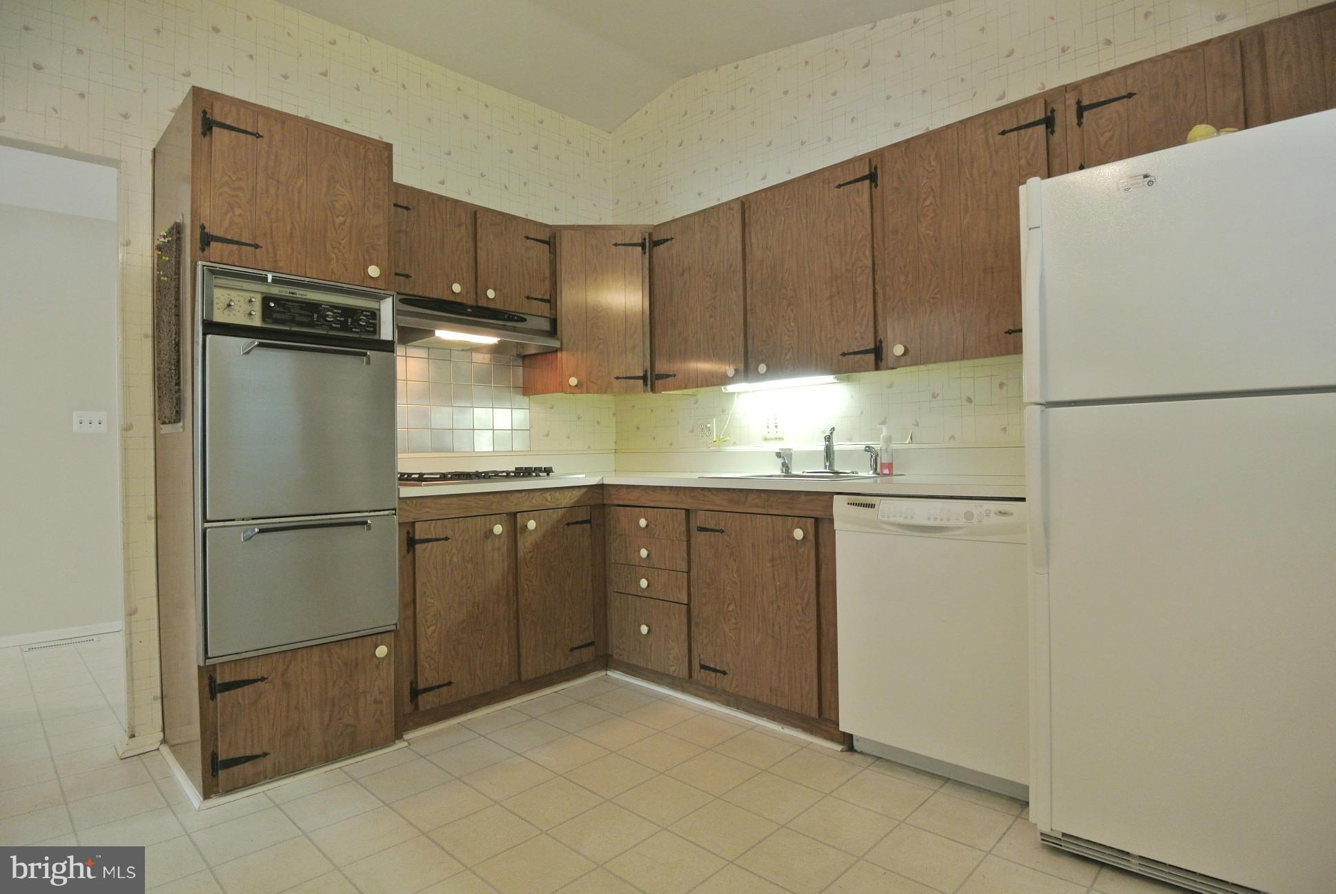 3906 Setonhurst Road Baltimore, MD 21208 - Photo 14 of 30 a kitchen with a refrigerator sink and cabinets