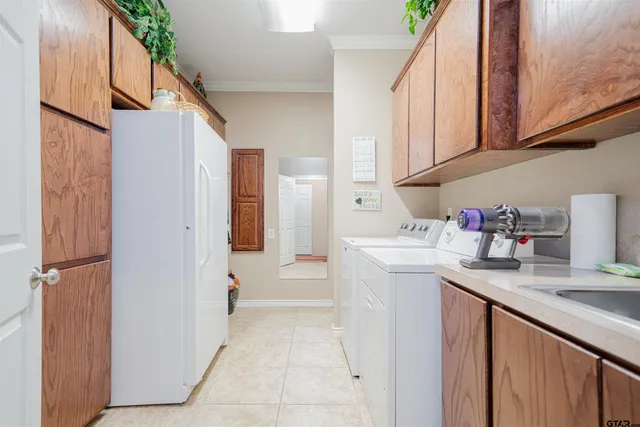 a utility room with cabinets washer and dryer