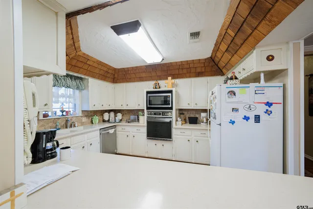 a kitchen with stainless steel appliances a stove a refrigerator and cabinets