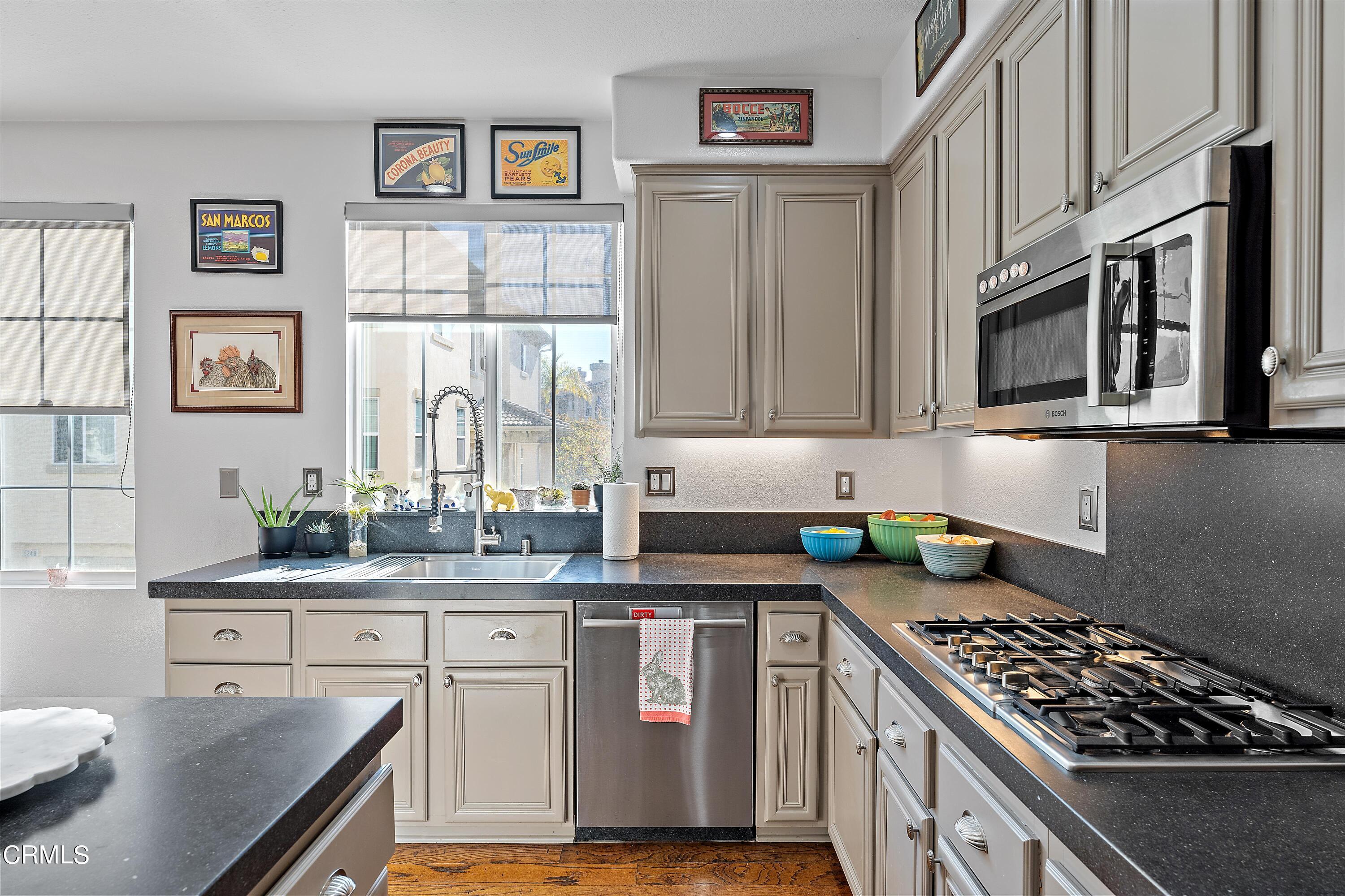 1239 Bayside Lane Oxnard, CA 93035 - Photo 11 of 27 a kitchen with stainless steel appliances granite countertop a stove top oven a sink dishwasher and cabinets with wooden floor