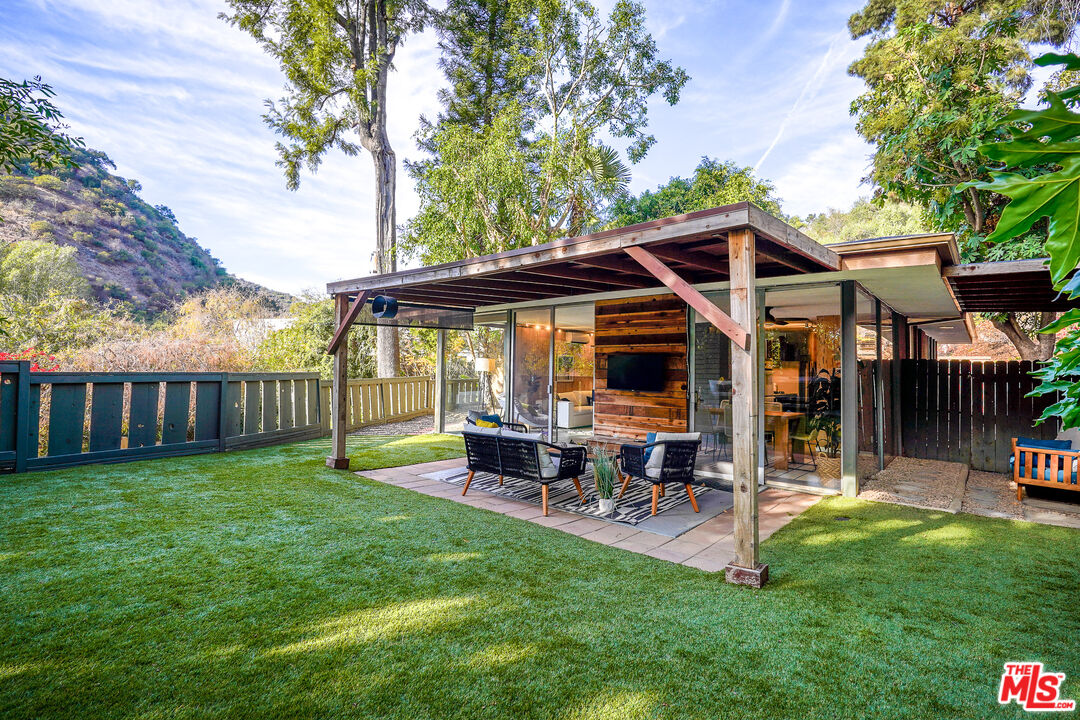 a view of a chair and table in backyard of the house
