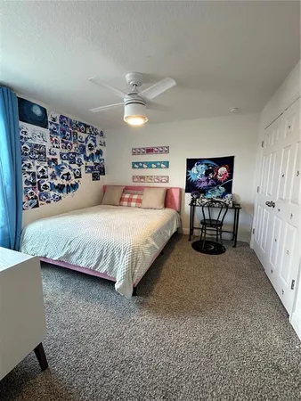 a bedroom with a large bed and a ceiling fan