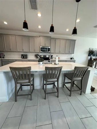 a kitchen with kitchen island a dining table and chairs