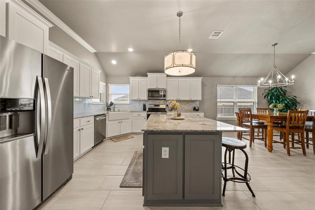 828 Agile Street Hewitt, TX 76643 - Photo 13 of 30 a kitchen with kitchen island granite countertop stainless steel appliances a stove center island a refrigerator and a dining table