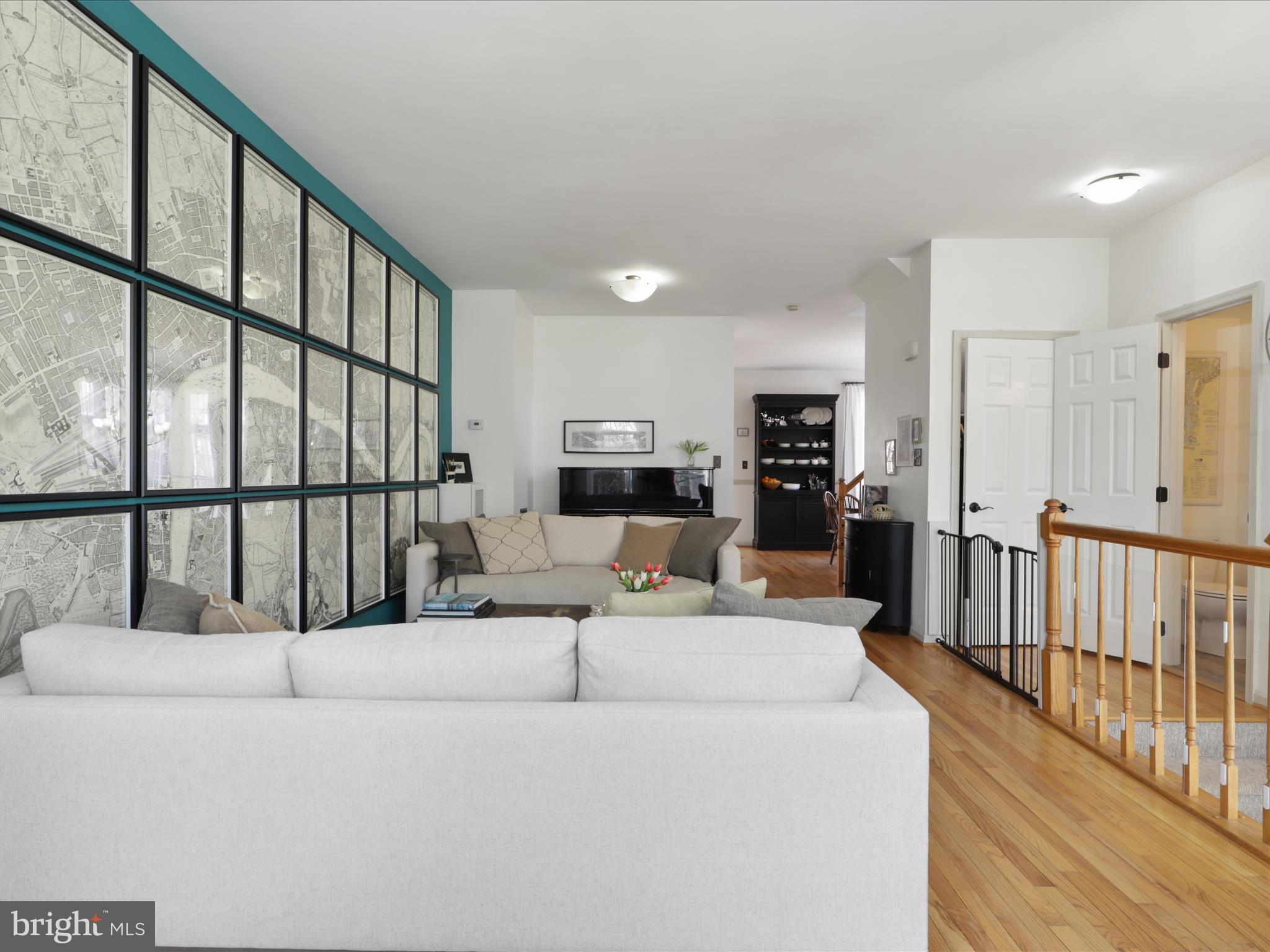 3906 Elbert Avenue Alexandria, VA 22305 - Photo 39 of 40 a living room with couches a flat tv screen and a refrigerator with wooden floor