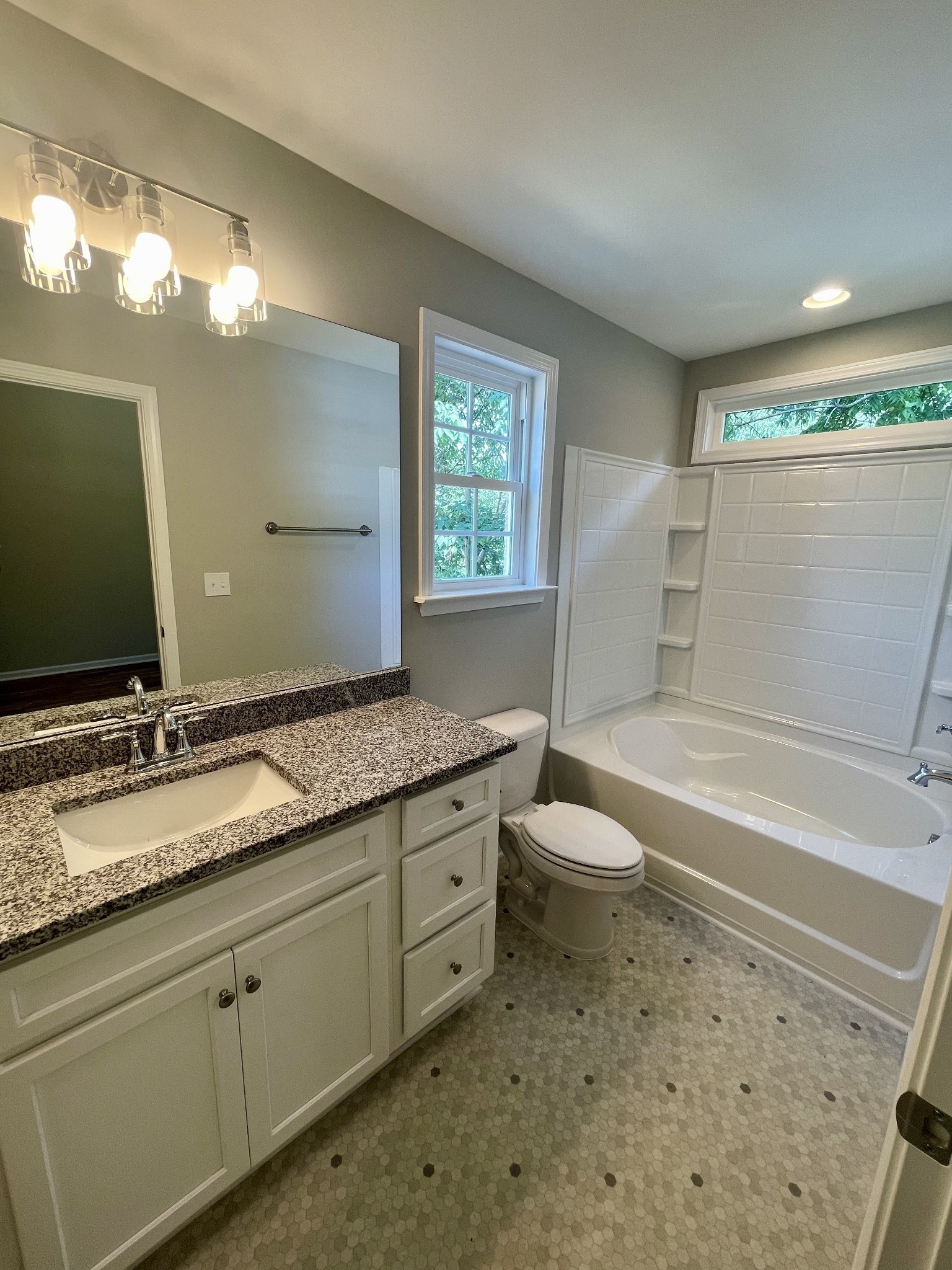 208 Power Avenue, Unit D Murfreesboro, TN 37129 - Photo 11 of 14 a bathroom with a granite countertop sink toilet a large mirror and a tub