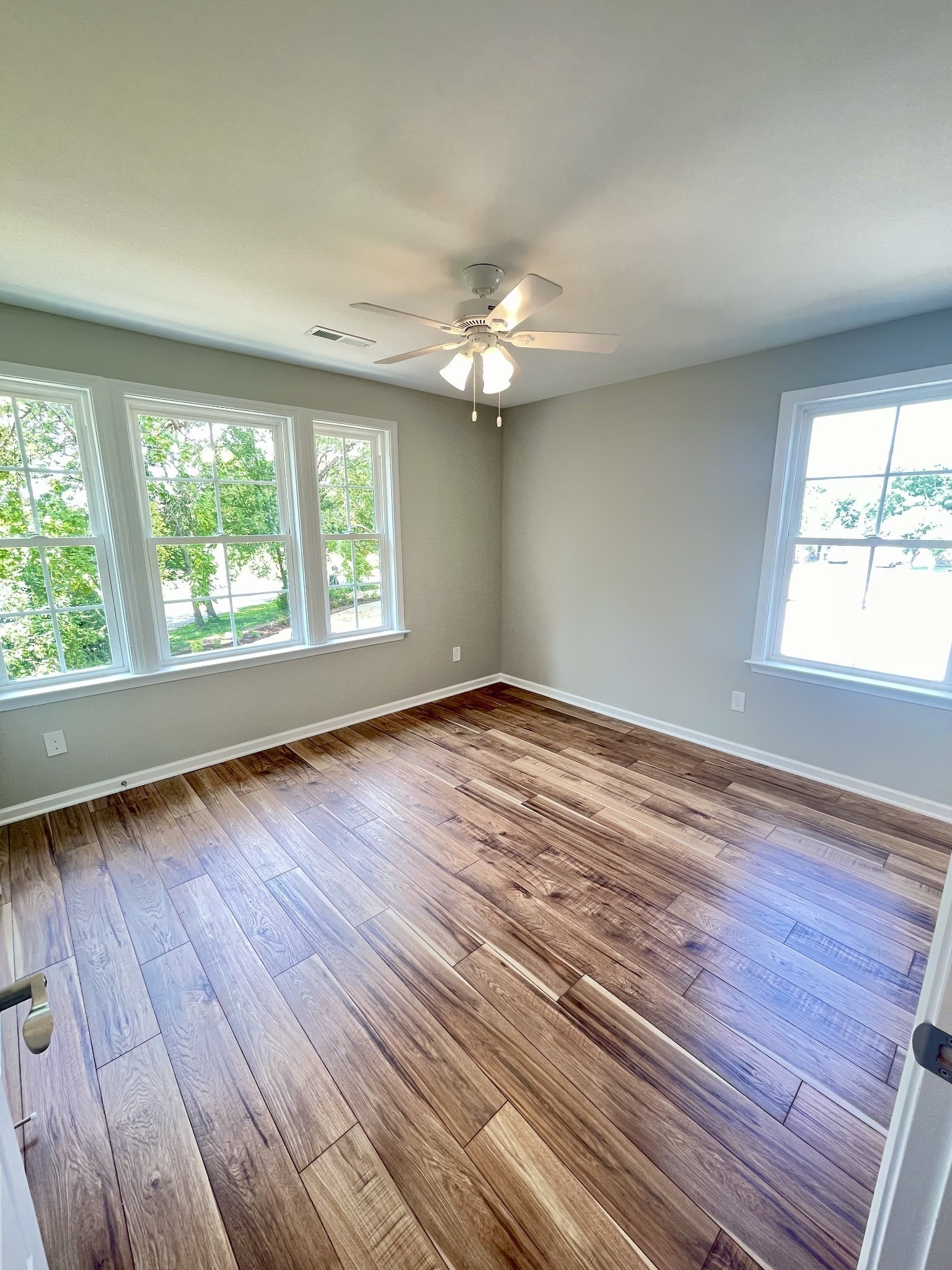208 Power Avenue, Unit D Murfreesboro, TN 37129 - Photo 13 of 14 an empty room with wooden floor chandelier fan and windows