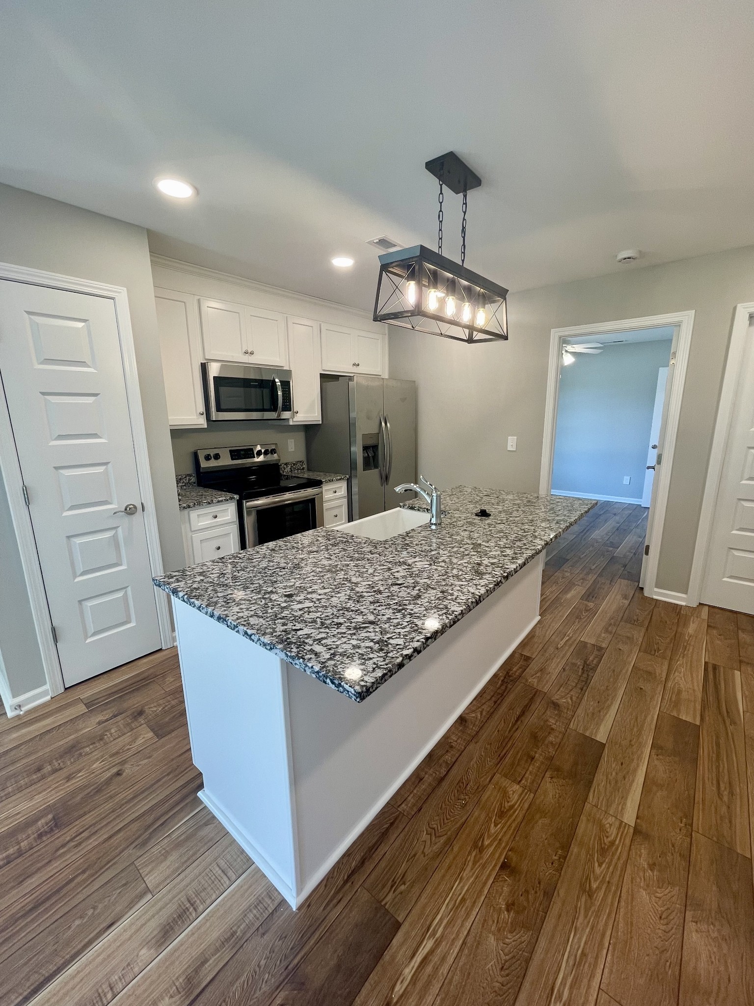 208 Power Avenue, Unit D Murfreesboro, TN 37129 - Photo 4 of 14 a kitchen with kitchen island granite countertop a sink stove and refrigerator