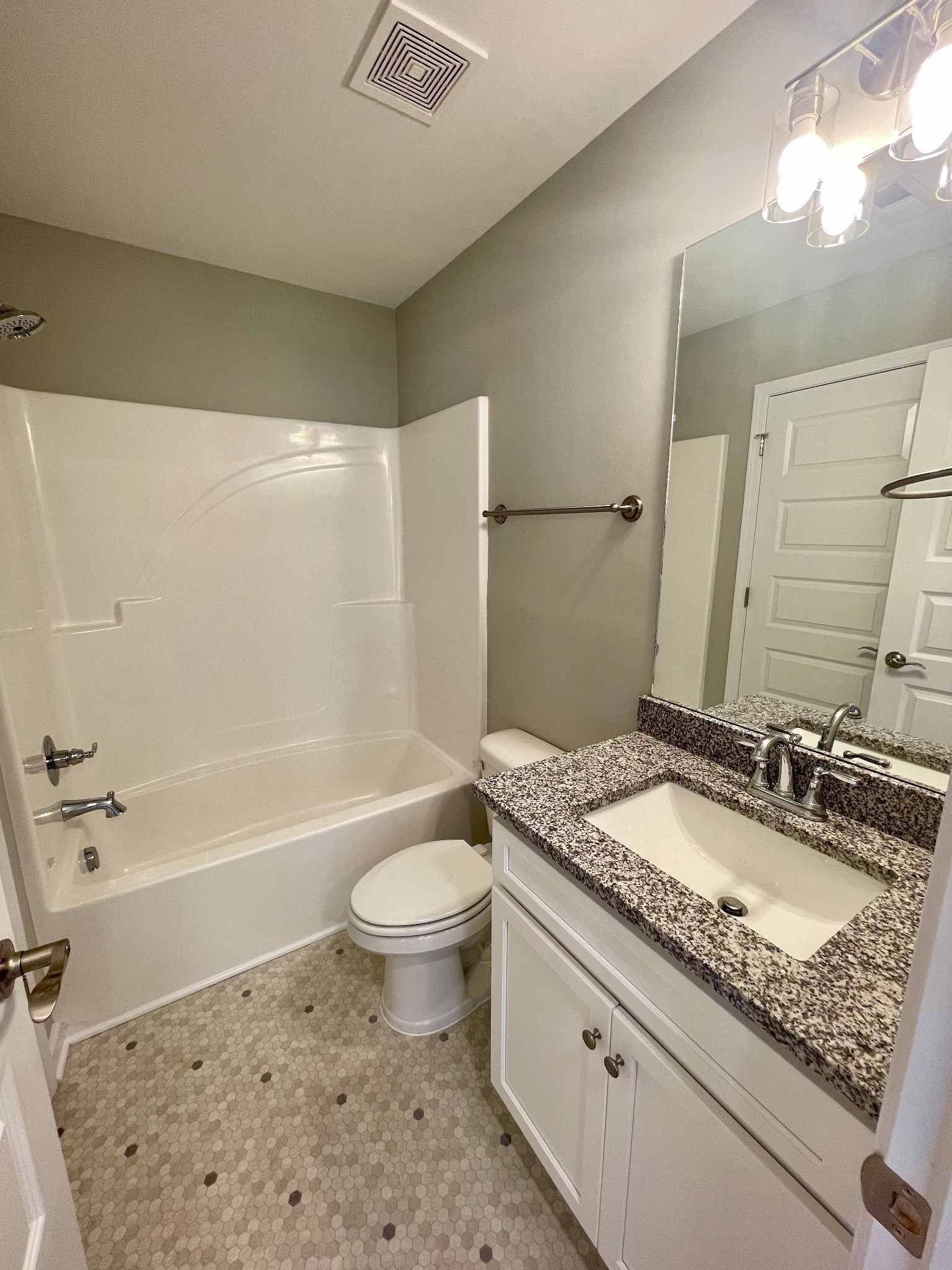 208 Power Avenue, Unit D Murfreesboro, TN 37129 - Photo 7 of 14 a bathroom with a granite countertop sink a toilet a mirror a bathtub and shower