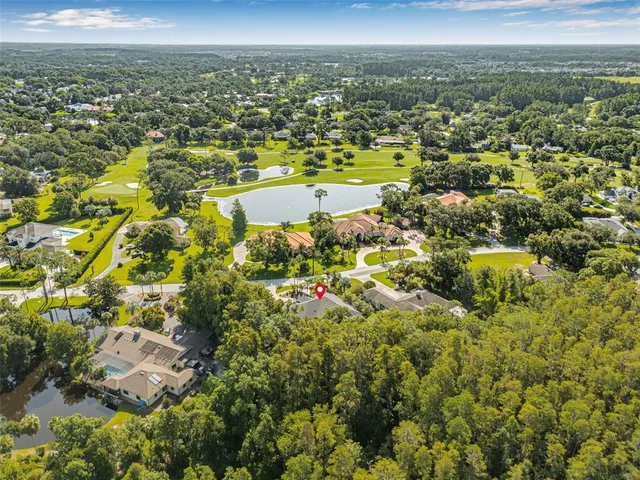 an aerial view of a house with a yard and lake view