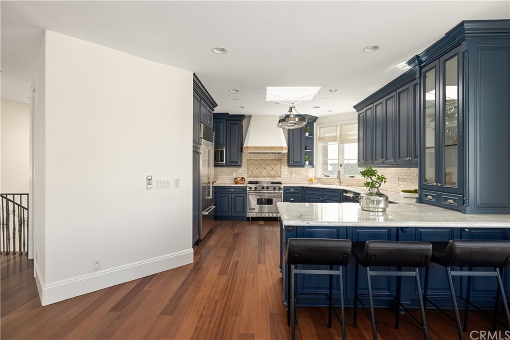 2211 Vista Drive Manhattan Beach, CA 90266 - Photo 23 of 48 a kitchen with kitchen island granite countertop wooden floors and chairs