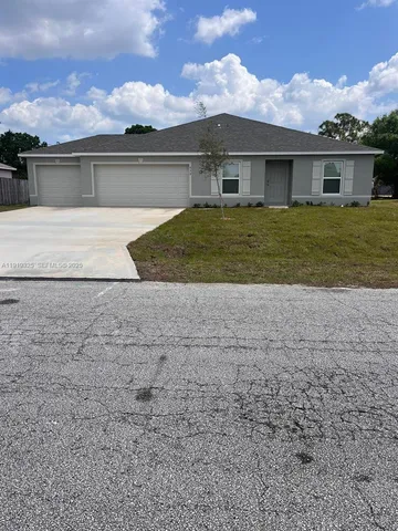 a view of house with yard and a garden