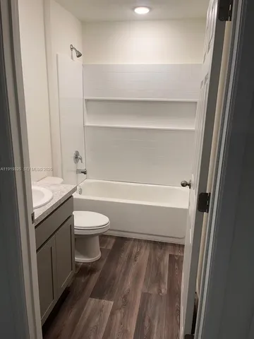 a bathroom with a granite countertop toilet a sink and a bathtub