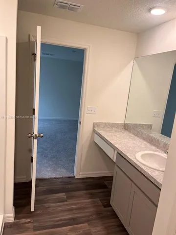 a utility room with cabinets and wooden floor