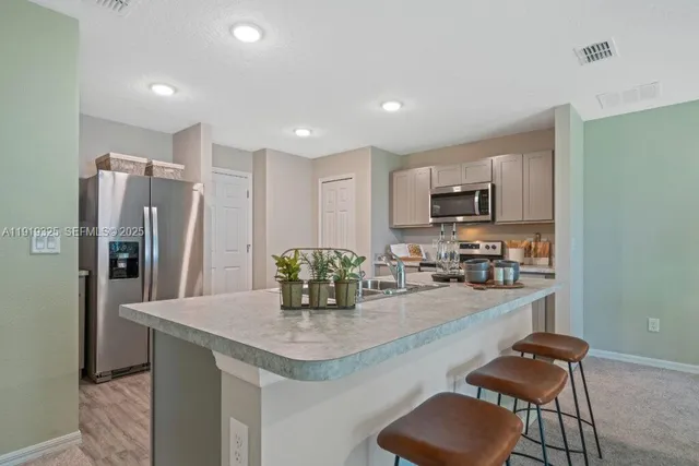 a kitchen with refrigerator and chairs