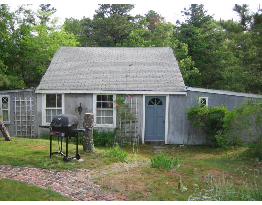 114 Upper County Road Dennis, MA 02660 - Photo 3 of 5 a front view of house with a garden and patio