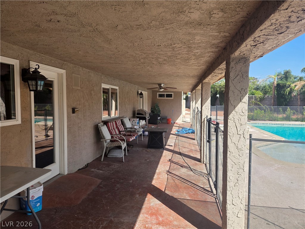 3381 Westwind Road Las Vegas, NV 89146 - Photo 11 of 52 An inviting covered patio offers ample space for outdoor living beside a shimmering pool.