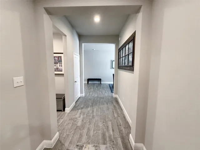 a view of a hallway with wooden floor and staircase