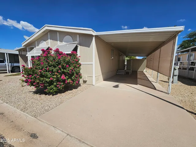 a front view of a house with a yard and potted plants