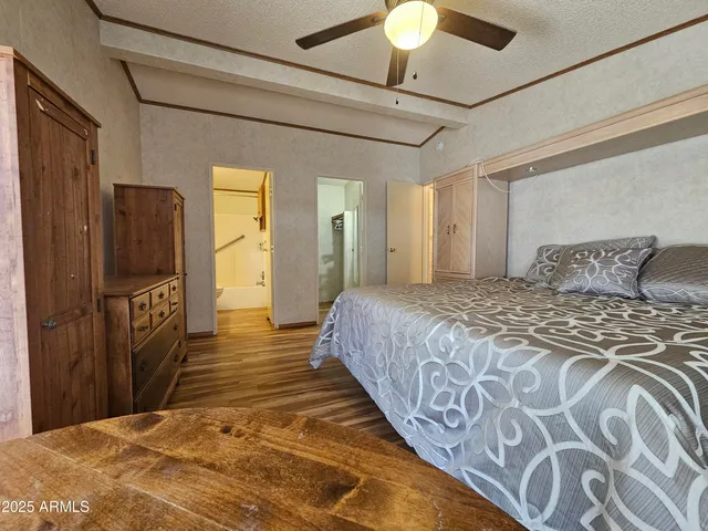 a bedroom with a bed dresser and a chandelier