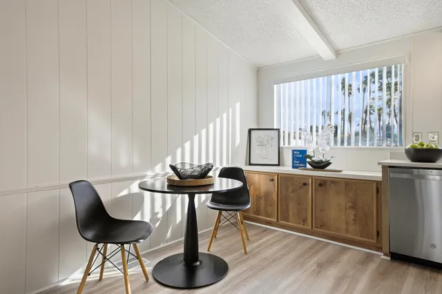 a kitchen with stainless steel appliances kitchen island a table and chair in it