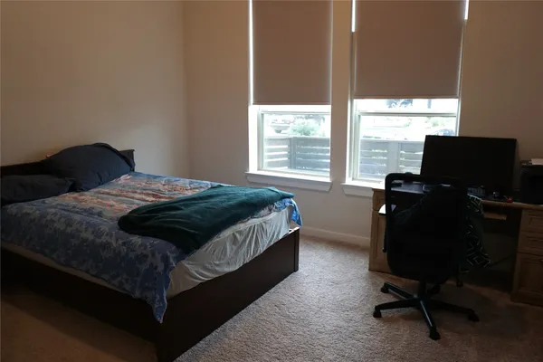 a bedroom with a bed window and a desk