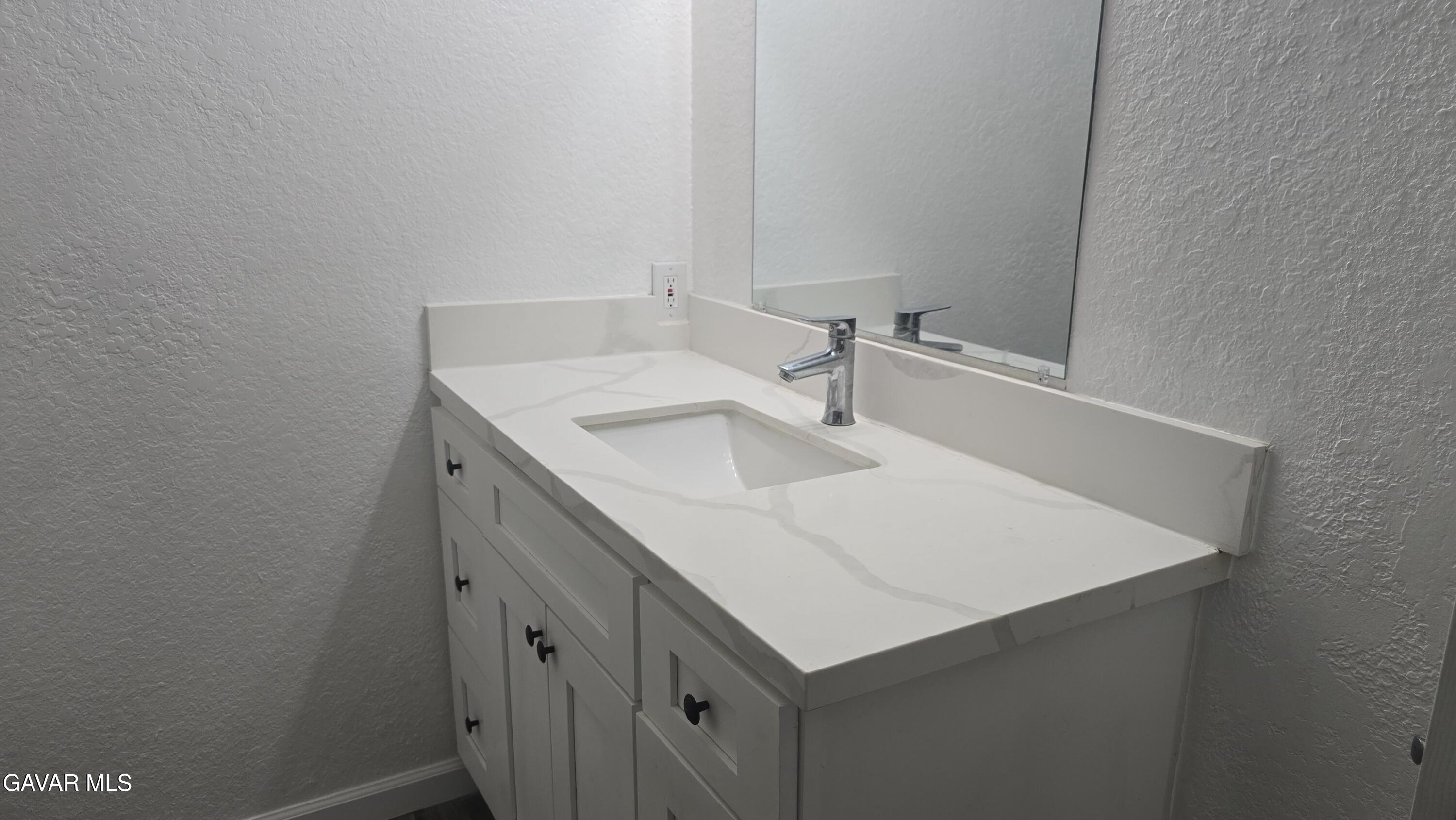 38551 10th Place East, Unit A Palmdale, CA 93550 - Photo 13 of 18 a bathroom with a sink and a mirror