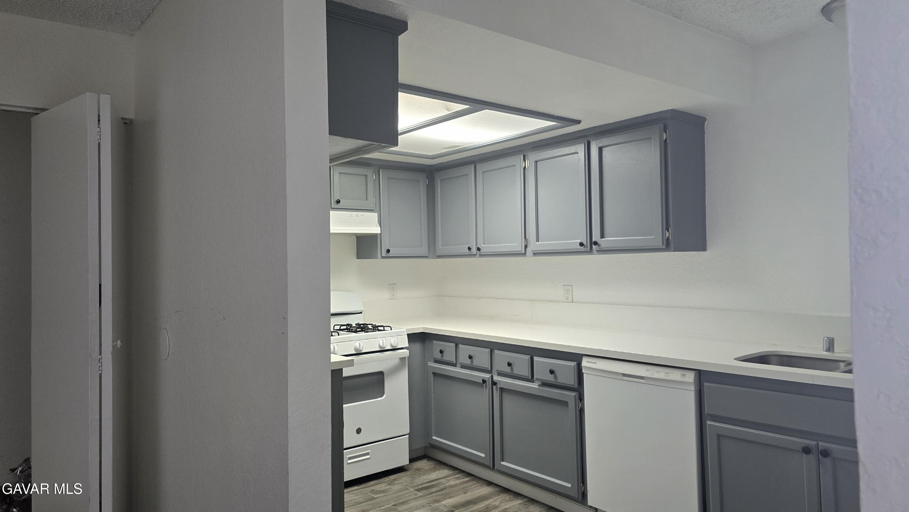 38551 10th Place East, Unit A Palmdale, CA 93550 - Photo 16 of 18 a kitchen with white cabinets and white appliances