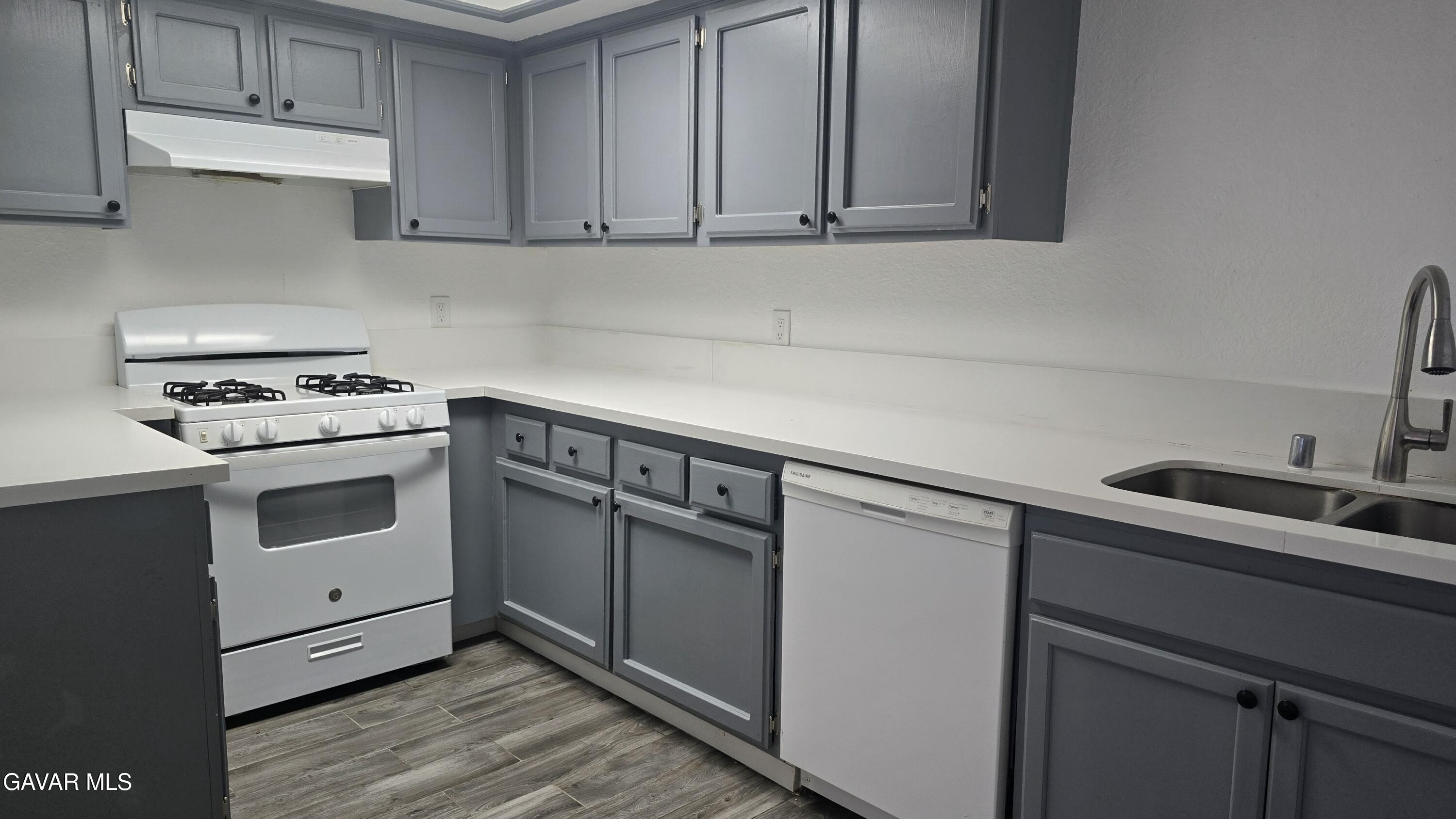 38551 10th Place East, Unit A Palmdale, CA 93550 - Photo 17 of 18 a kitchen with granite countertop white cabinets and white appliances