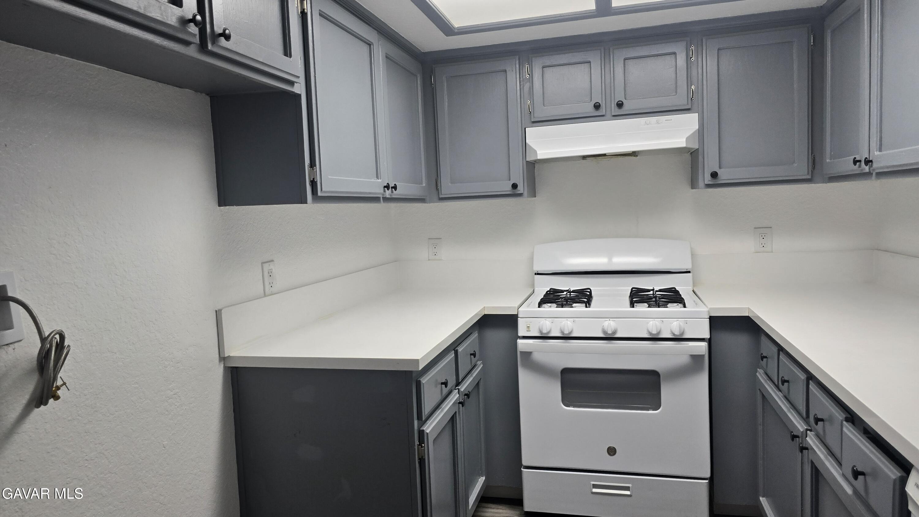 38551 10th Place East, Unit A Palmdale, CA 93550 - Photo 18 of 18 a kitchen with a stove top oven sink and cabinets