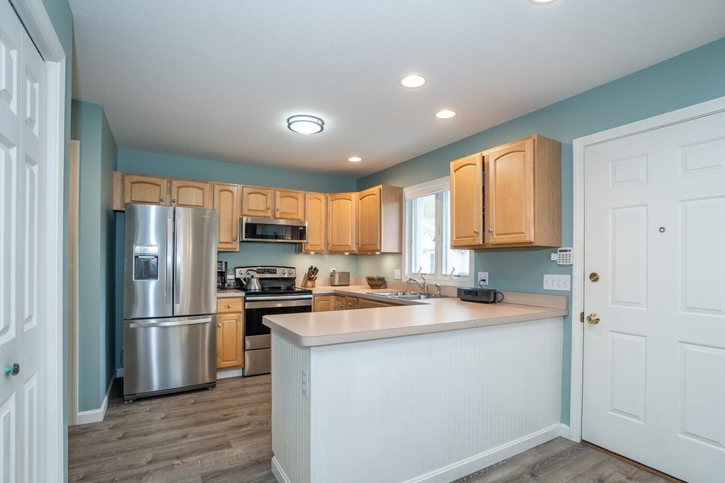 399 Bridge Road, Unit F Northampton, MA 01062 - Photo 8 of 40 a kitchen with a refrigerator sink and cabinets
