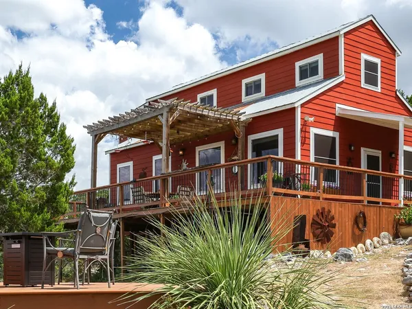 a front view of a house with a yard and potted plants